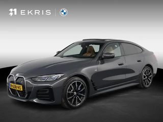 BMW i4 eDrive40 High Executive 84 kWh Dravitgrau met Cognac Volleder | M Sport | Elektrisch Schuif-/kanteldak | M Stoelen Elektrisch | Harman Kardon | Laserlight | Camera | Comfort Access